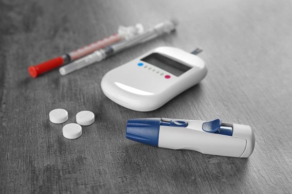 Composition with digital glucometer on grey background. Diabetes concept